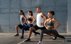 Grupo fazendo avanço com as mãos na cintura em treino funcional ao ar livre